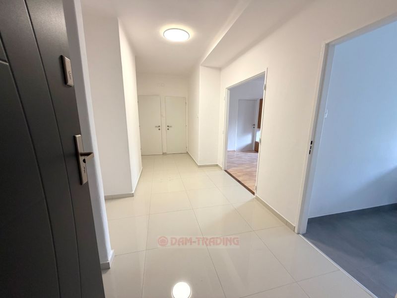 A bright hallway in a 2-room apartment with ceramic flooring and white walls.