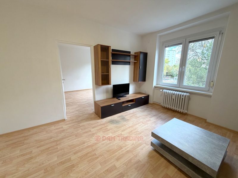 Living room with a TV stand, coffee table, and wooden decor flooring.