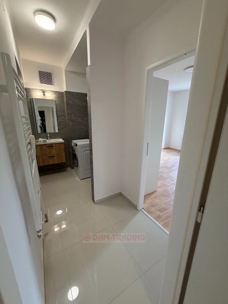 A hallway in a 2-room apartment with access to a bathroom with a washing machine.