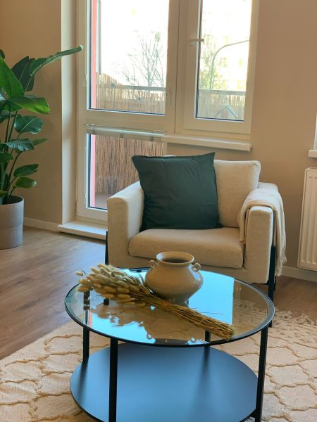 Living room of a two-room apartment with an armchair and a coffee table, floor with wooden decor.