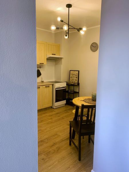 Kitchen corner with dining table and chairs, 2-room apartment, floor with wood decor.