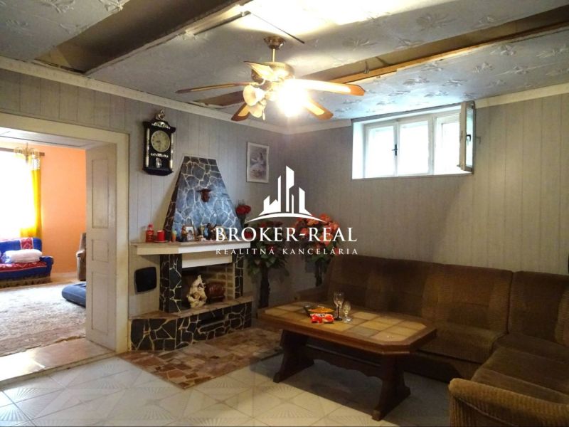 Living room in a family house with a fireplace, table, and sofa.