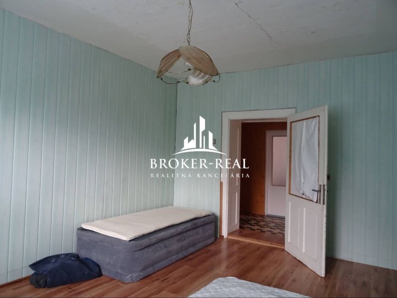 A room in a family house with a bed and a wooden decor floor.