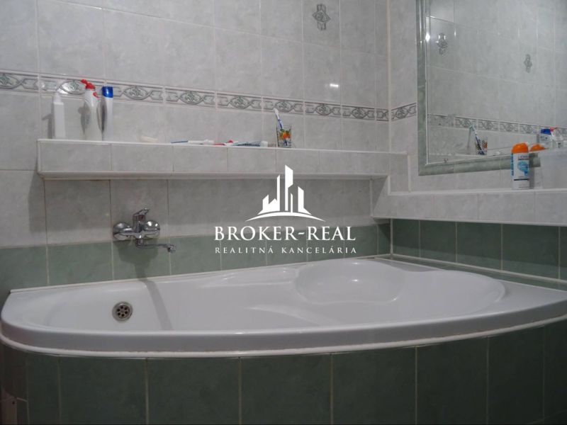 Bathroom with a bathtub and a mirror in a family house.