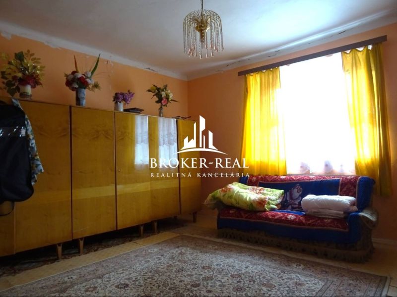 A living room in a family house with a colorful carpet and curtains.
