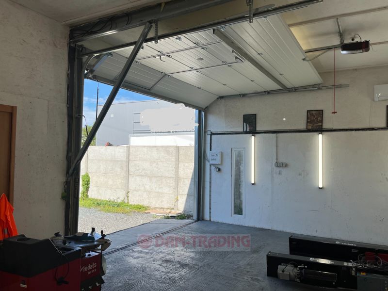 Garage in Gardens with open gates, view of the paved area.