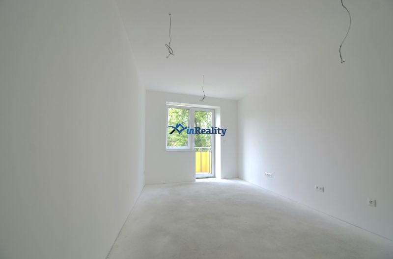 Empty room with white walls and floor in a two-room apartment.