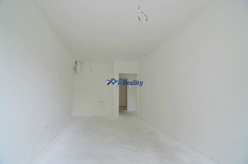 An empty room in a 2-room apartment with clean white walls and floor.