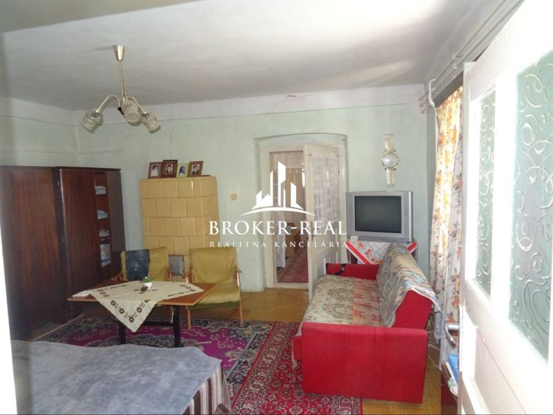 Living room in a family house with a tiled stove and a floor with a wooden decor.