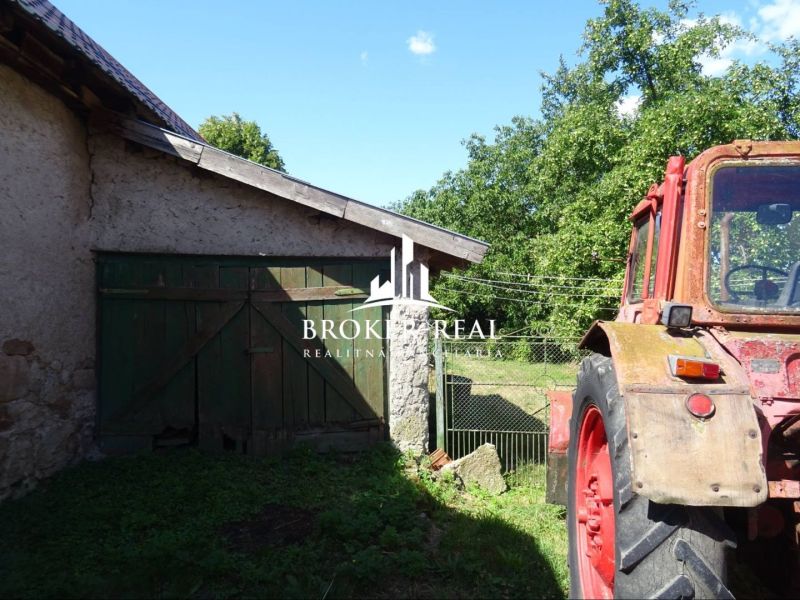 An old tractor next to a barn on the property of a family house in Abaújvár.