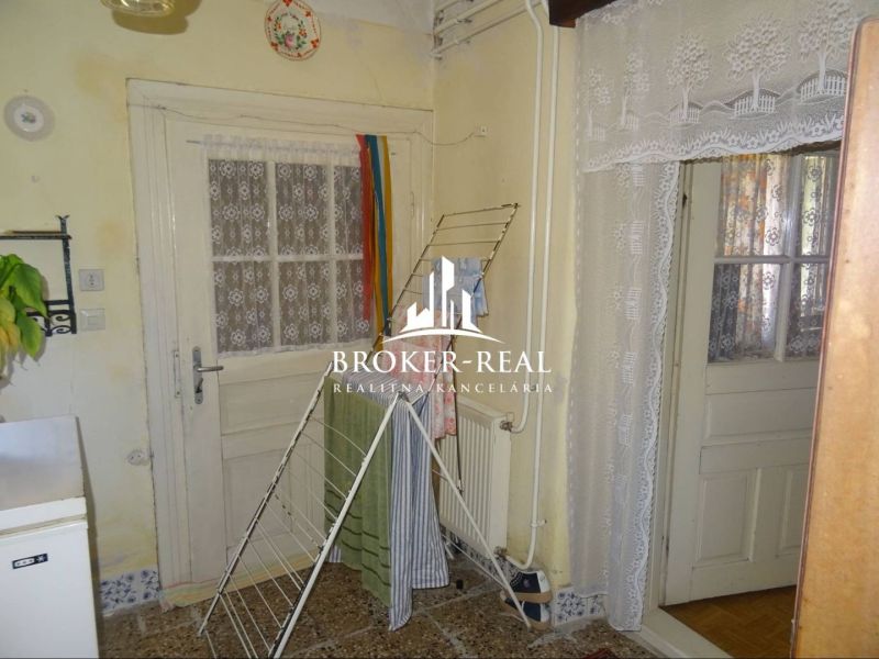 Interior of a family house with doors, curtains, and a clothes drying rack.