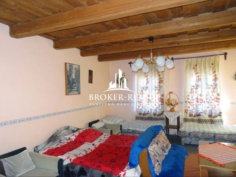 Living room in a family house with a ceiling made of wooden beams and cozy furnishings.