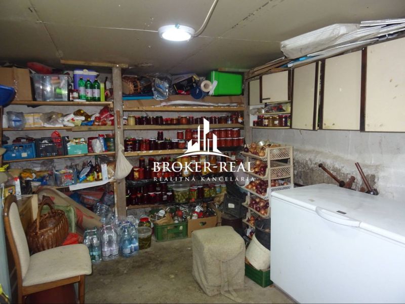 A compact cellar with shelves for preserves and storage space in a family house.