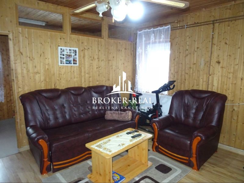 Living room in a family house with wooden decor and a leather sofa set.