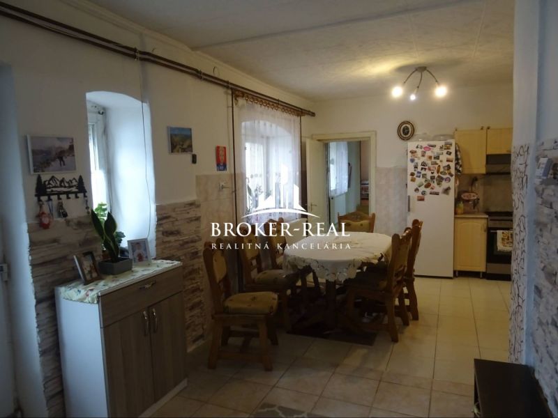A kitchen in a family house with a dining table and decorative wall cladding.