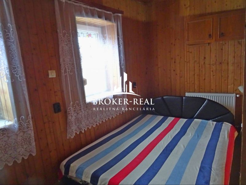 A bedroom with wooden wall decor and a double bed in a family house.