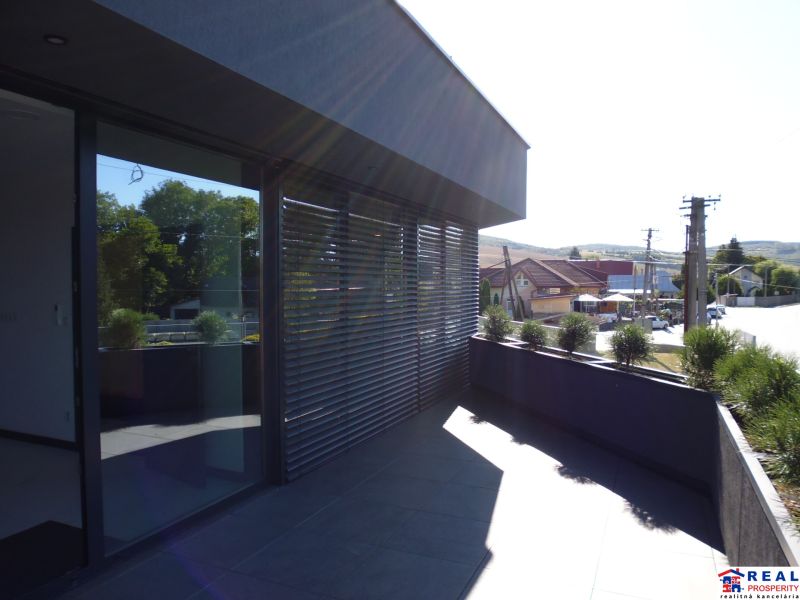 Terrace near warehouses and halls in Kračúnovce with a view of the street and greenery.