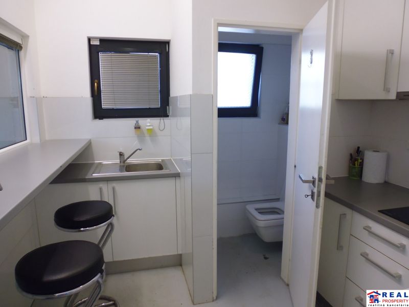 Kitchen corner with chairs and a sink, the door leads to the toilet in the Warehouses and Halls.