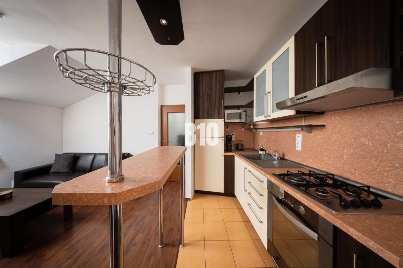 A kitchen with a counter and floor with wood decor in a 2-room apartment.