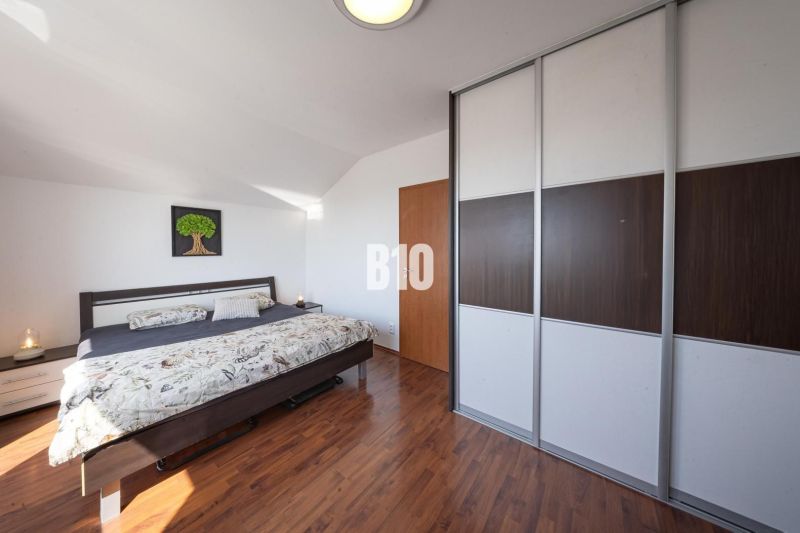 Bedroom in a 2-room apartment with a bed and built-in wardrobe, floor with wood decor.