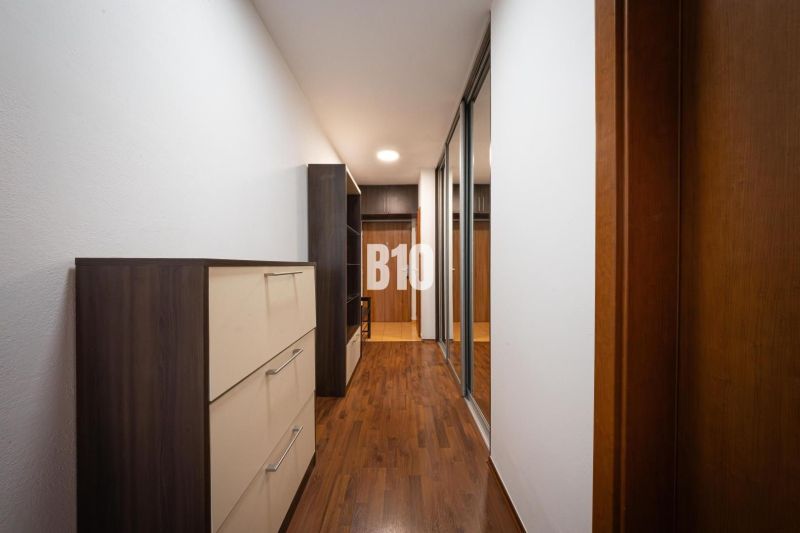 A hallway in a 2-room apartment with a wooden decor floor and built-in wardrobes.