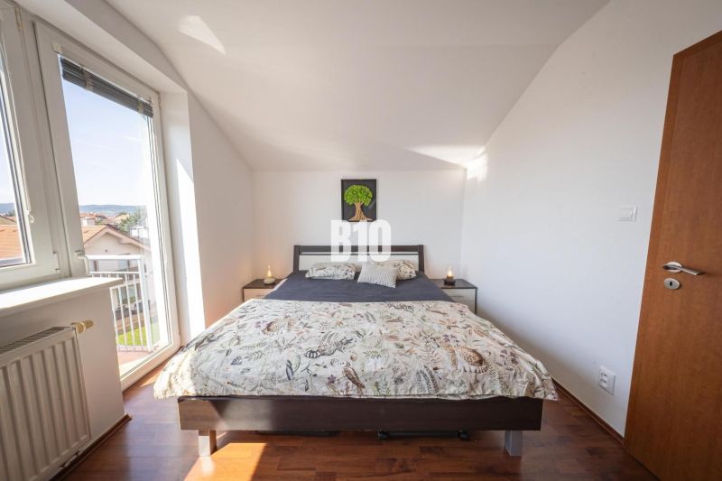A bright bedroom with a large bed and a wooden decor floor in a 2-room apartment.