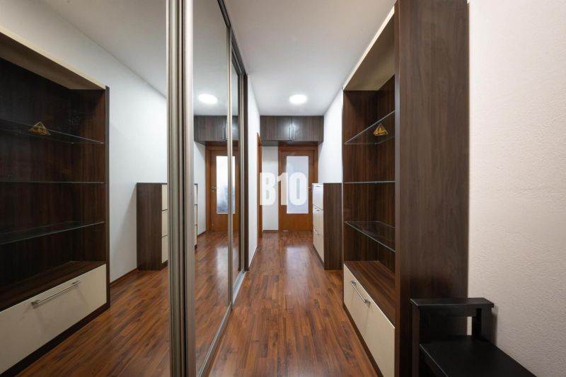 A hallway with a wooden decor floor and built-in wardrobes in a 2-room apartment.