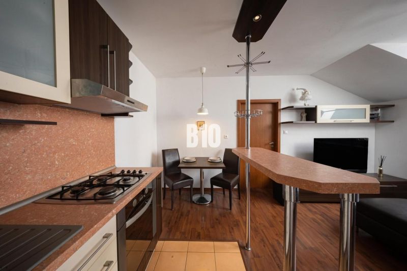 A kitchen with a bar counter and a wooden decor floor in a 2-room apartment.
