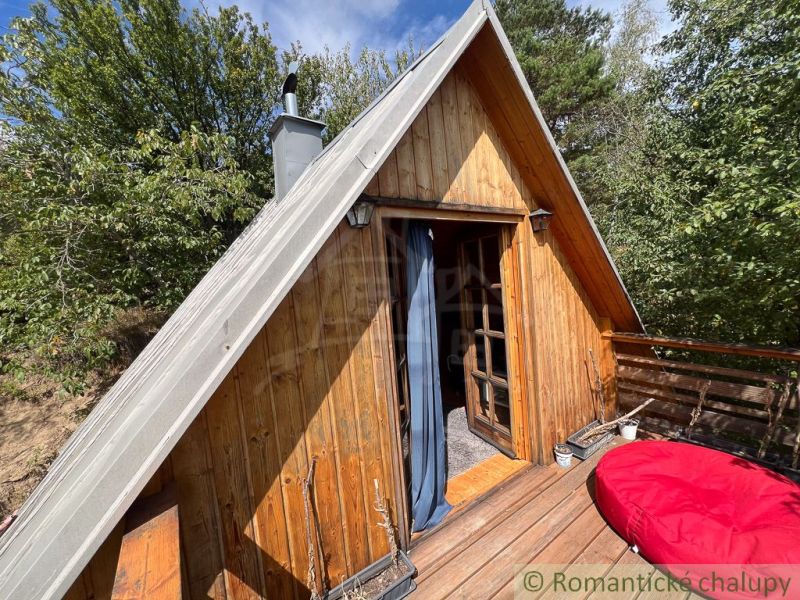 Wooden cottage with a terrace in the natural environment of Bratislava IV surrounded by greenery.