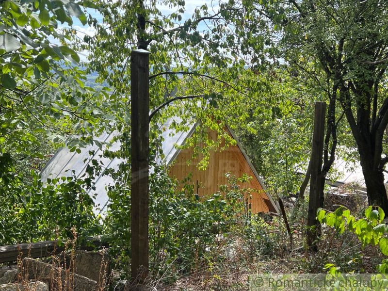 A wooden cabin in the nature of Bratislava IV surrounded by trees and greenery.