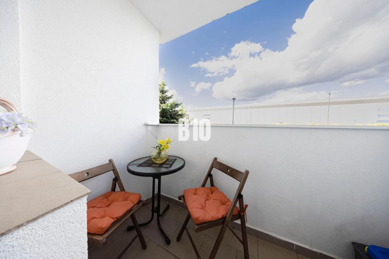 A balcony of a 3-room apartment with seating, a view of the sky, and flowers in Bratislava IV.