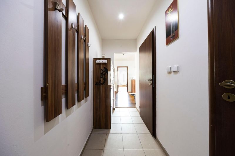 A hallway with a coat rack and tiles leads to a 3-room apartment.
