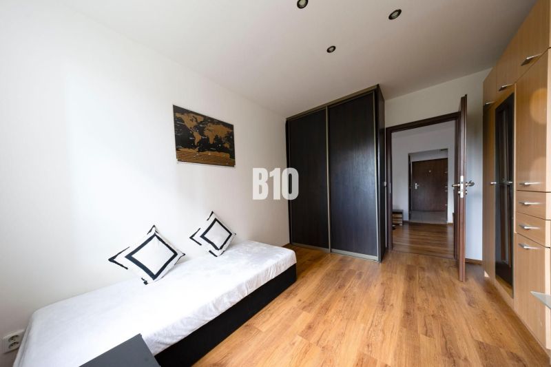 A simple room with storage cabinets, a bed, and a wooden decor floor in a 3-room apartment.