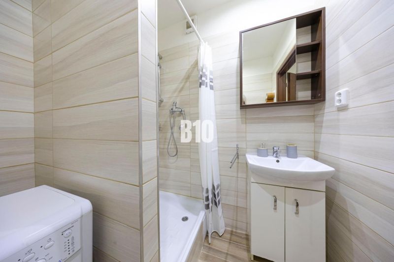 A bathroom in a 3-room apartment with a washing machine and a shower.