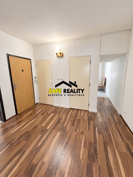 Interior of a 3-room apartment with a wooden decor floor and white walls.