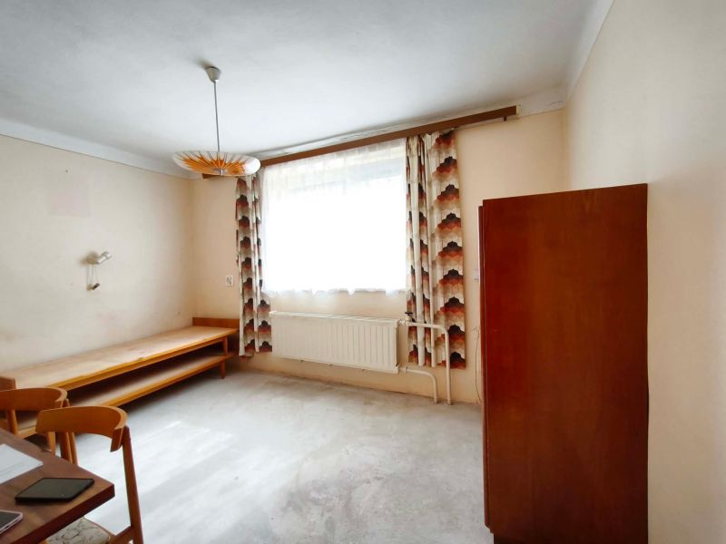 A room in a family house with furniture and curtains on the window.