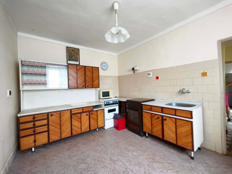 A kitchen in a family house with retro cabinets and a built-in stove.
