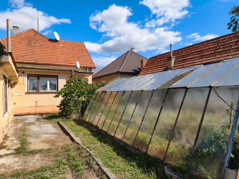 A family house in Oslany with a glass greenhouse and a satellite dish.