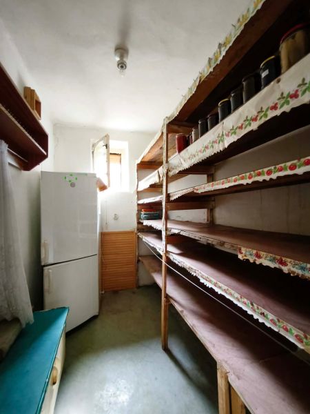 A pantry in a family house with shelves and a refrigerator.