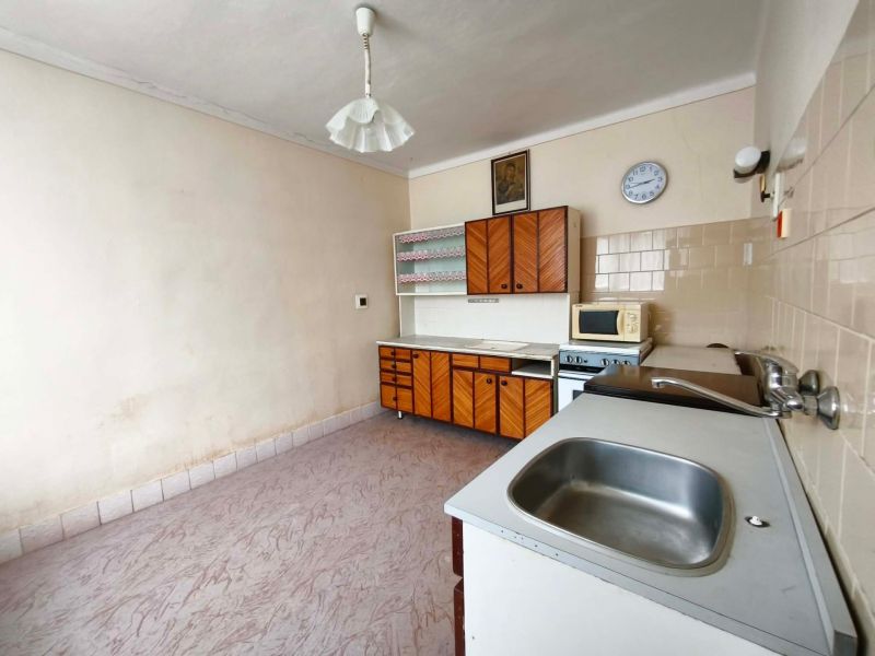 A kitchen in a family house with a wooden decor floor and retro furniture.