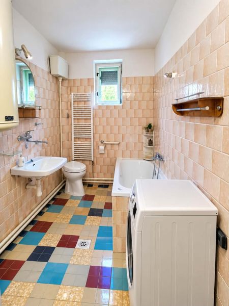 A bathroom in a family house with a shower, a bathtub, and mosaic flooring.