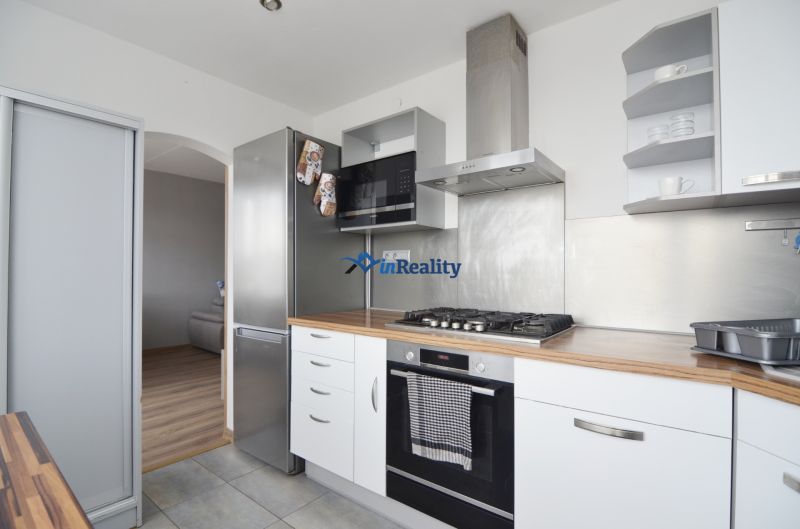 A kitchen in a 4-room apartment with a wooden decor and built-in appliances.