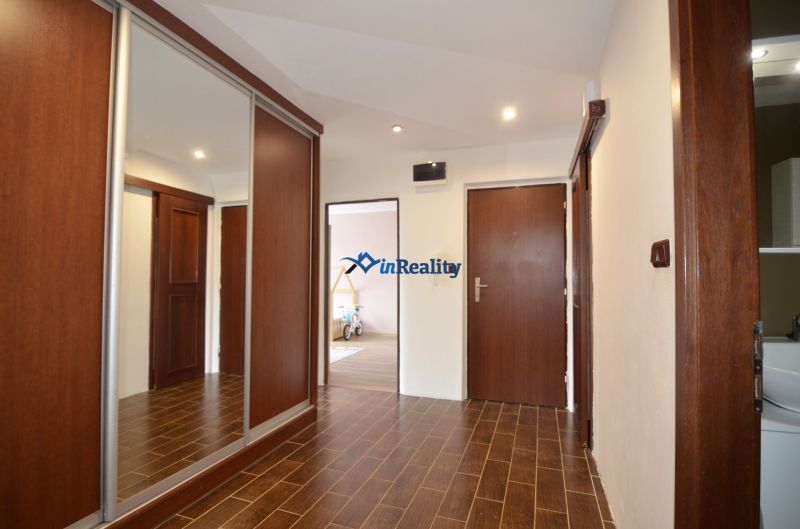 Entrance hall in a 4-room apartment with a wood-decor floor and a built-in wardrobe.