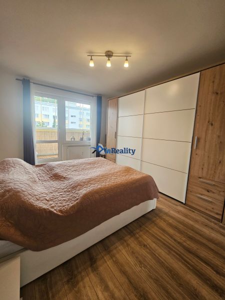 Bedroom in a 4-room apartment with a large wardrobe and a wooden decor floor.