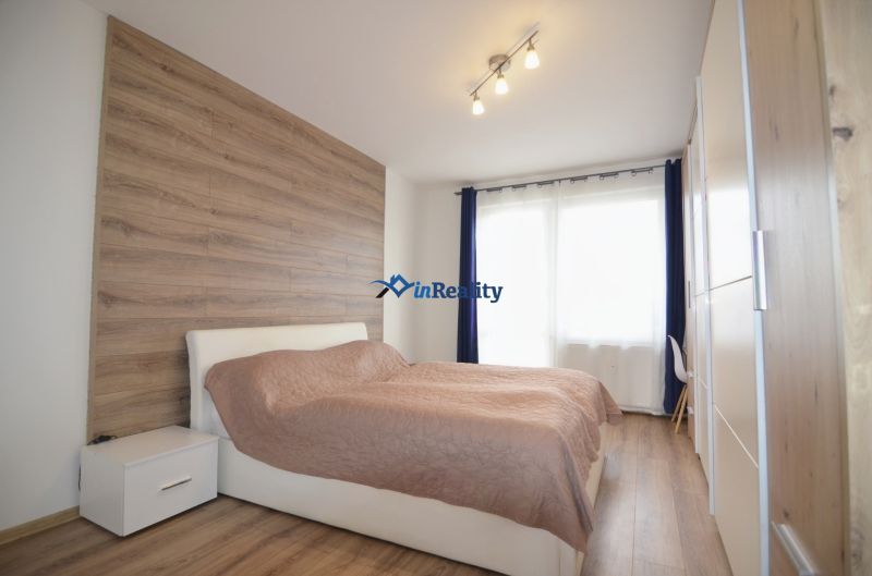 Bedroom with wood-patterned flooring in a 4-room apartment, bright space.