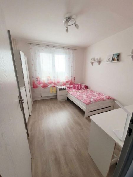 Bedroom with a bed and wooden decor flooring in a 2-room apartment.