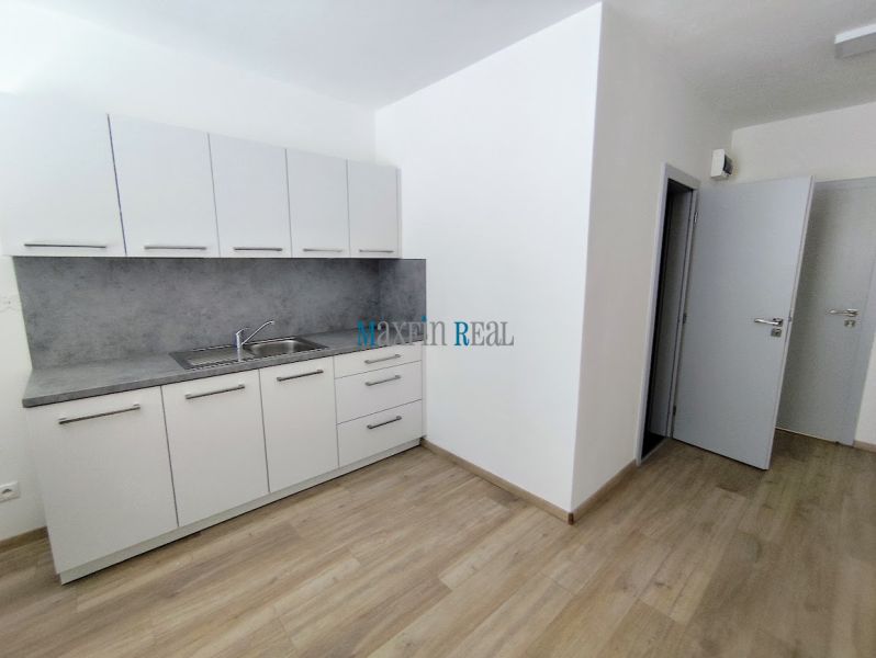 White cabinets with a countertop, floor with wood decor in the office.
