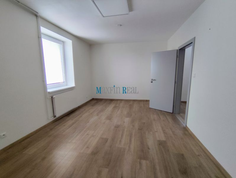 Offices with wood-patterned flooring and windows in a white interior.