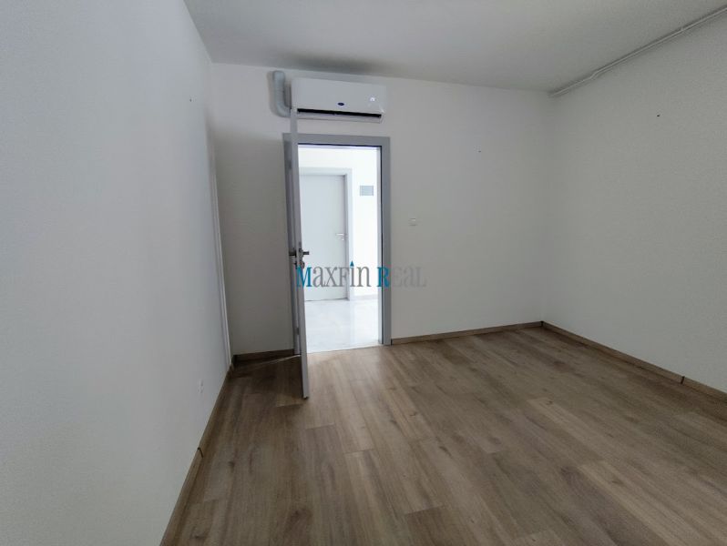 A room in an office with a wooden decor floor and air conditioning.