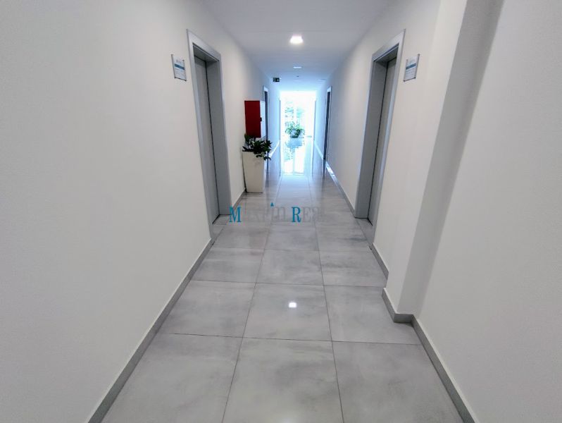 A hallway in an office with light walls and flooring, located in Nitra - Chrenová.